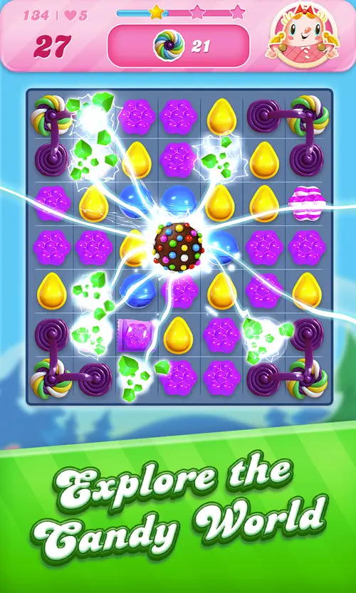 Candy Crush-pálya: lila és sárga cukorkák között felrobban egy színes bomba, fent a 134-es szint és öt élet, a kép alján angol felirat – Explore the Candy World